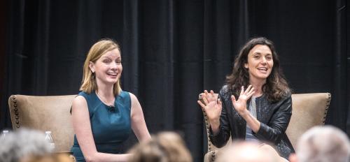 The Pollsters podcast hosts Kristen Soltis Anderson and Margie Omero speak on stage at an event