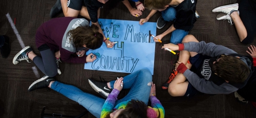 Young students creating a "We March 4 Equality" poster. 