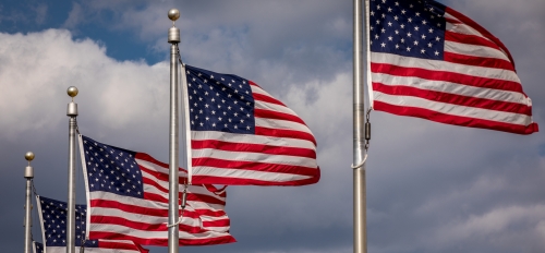 Four flagpoles flying American flags
