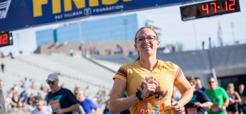 woman wearing Sparky T-shirt crosses race finish line