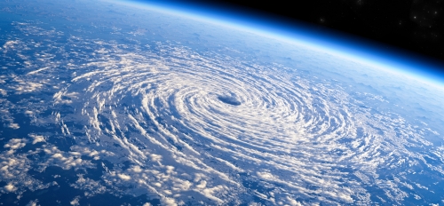 A hurricane forming above an ocean as seen from space.