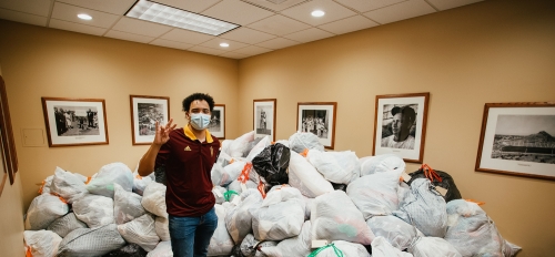 ASU student Ahlias Jones stands by nearly 2,000 pounds of clothing donated by students in the Medallion Scholarship Program