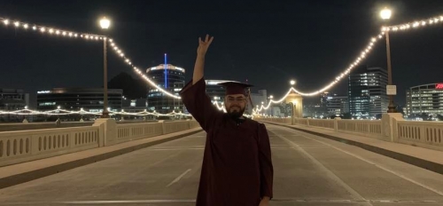 ASU grad Angel Morales giving a forks up on the Mill Avenue bridge