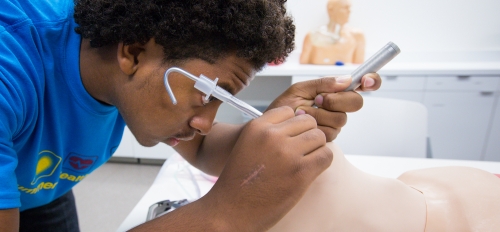 student practices intubation on a medical manikin