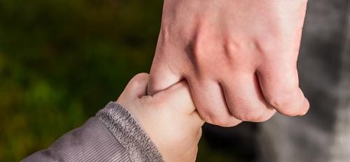 child holding adult's hand