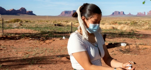 iStock photo of a Navajo woman using hand sanitizer