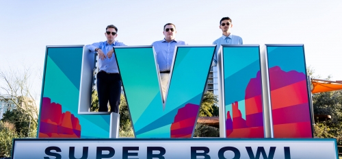 Trio of ASU students standing behind Super Bowl sign in Phoenix.
