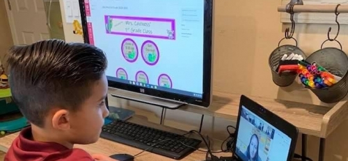 Child using computers to learn online at home