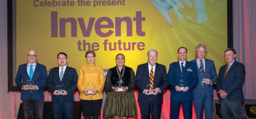 Group photo of people standing on stage holding awards.