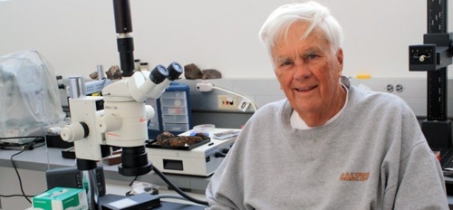 ASU Emeritus Regents Professor Carleton Moore seated in a lab in front of a microscope