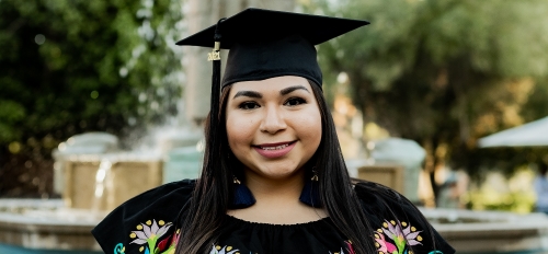 Carolina Tovar in her graduation cap in front of the Old Main fountain at ASU's Tempe campus