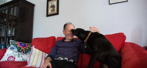 man and dog on couch