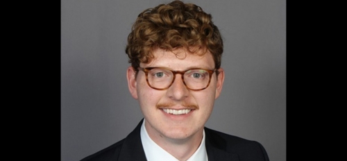 man with glasses and mustache in a suit