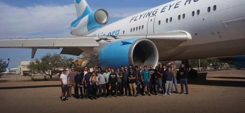 Group photo of ASU Professor of Practice Timothy Takahashi and members of the student groups AIAA@ASU and Air Devils standing next to a large plane.