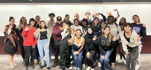 Group of ASU students posing for a photo and making the pitchfork symbol with their hands.