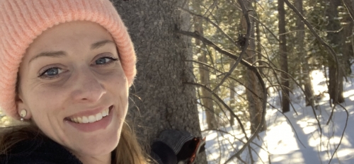 ASU Online student Hayley Rose posing for a selfie in a wooded, snowy area while wearing a jacket and beanie.