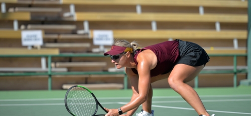 Ilze Hattingh, Sun Devil, crouches on the court while playing women's tennis