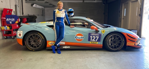 woman posing in front of race car