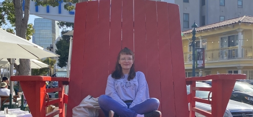 ASU student Genevieve Hook sitting in an oversized, red chair.