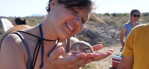 woman holding small mammal in her hands