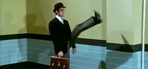An actor does the silly walk from Monty Python's Flying Circus, with one leg kicked crazy high
