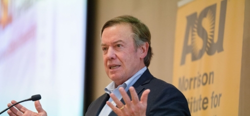 ASU President Michael Crow speaking into a microphone at an event.