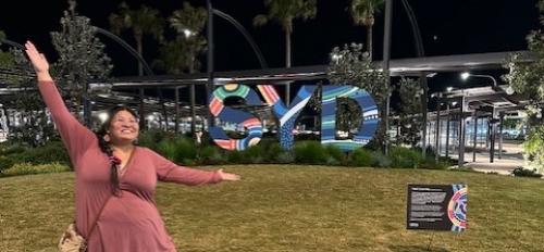 ASU student Nicholet Deschine Parkhurst posing in front of large letters that read "SYD" in Sydney, Australia.