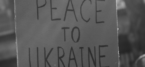 Woman holding sign that says "Peace to Ukraine."