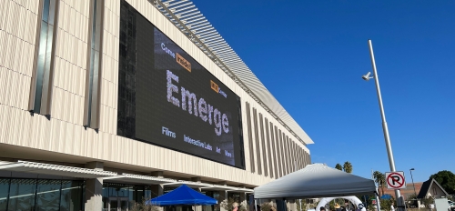 Exterior of the MIX Center with a logo for the Emerge event on large outdoor screen.