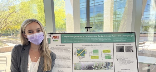 ASU undergrad standing next to a poster at a conference.
