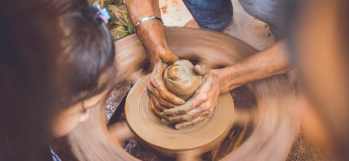 photo of hands at potter's wheel