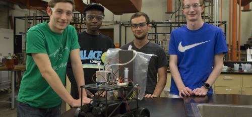 Photo of Jayse Langdon, Jon Simiyu, Andrew Dopilka and Alex Cook as they work on their fuel-cell-powered car in preparation for the national American Institute of Chemical Engineers' Chem-E-Car competition this November. 