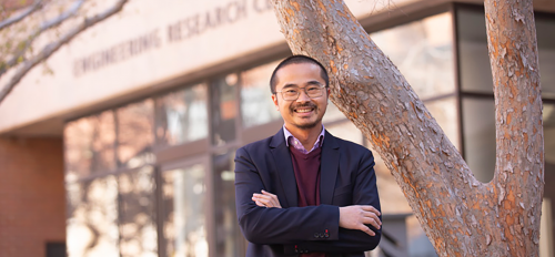 Houlong Zhuang posing in front of ASU's Engineering Research Center. 
