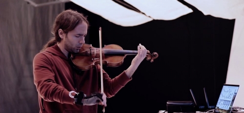 Instructor and violinist Seth Thorn holding his hybrid violin 