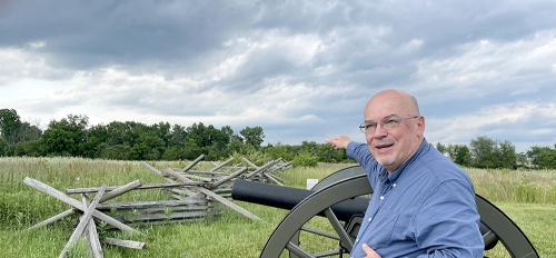 Brooks Simpson next to Civil War replica cannons on the Gettysburg battlefield.