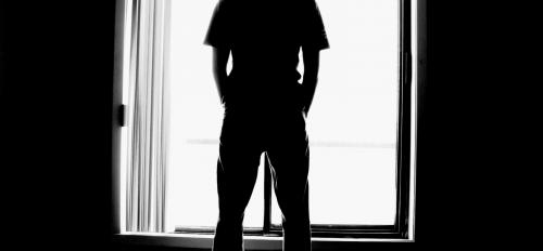 Man stands at a window.
