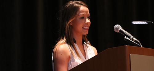 student speaking at podium during luncheon
