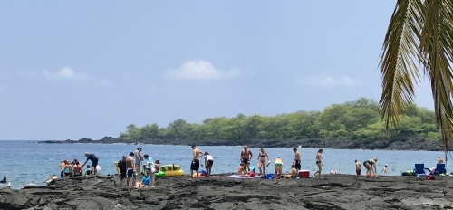 Tourists fill a Hawaiian beach.