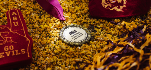 The College Dean's medal surrounded by gold flowers and sprit gear.