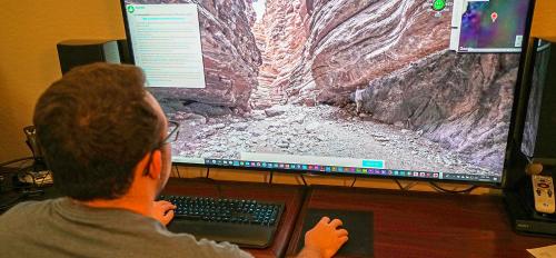 Man on computer exploring a canyon through a virtual field trip