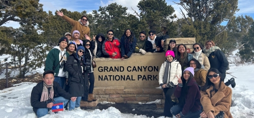 YSAELI fellows posting near sign for the Grand Canyon National Park, surrounded by snow and trees.