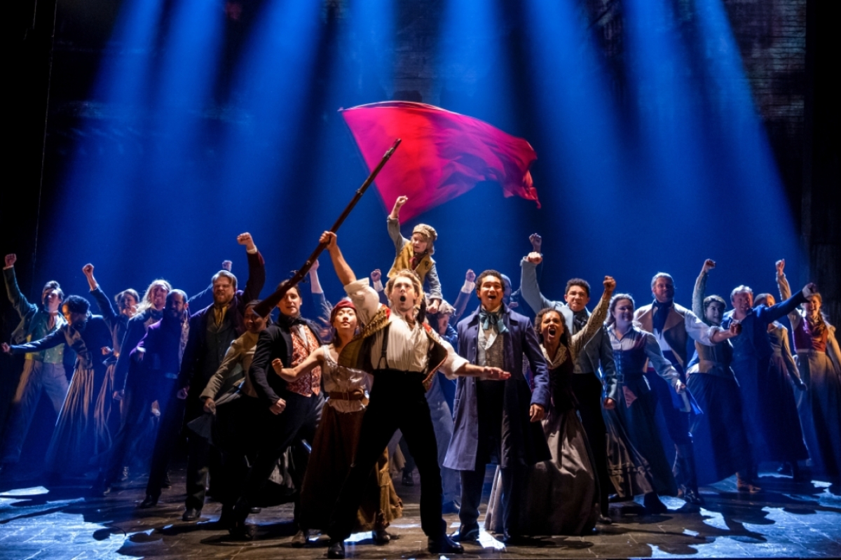 Cast members in "Les Misérables" performing on stage.