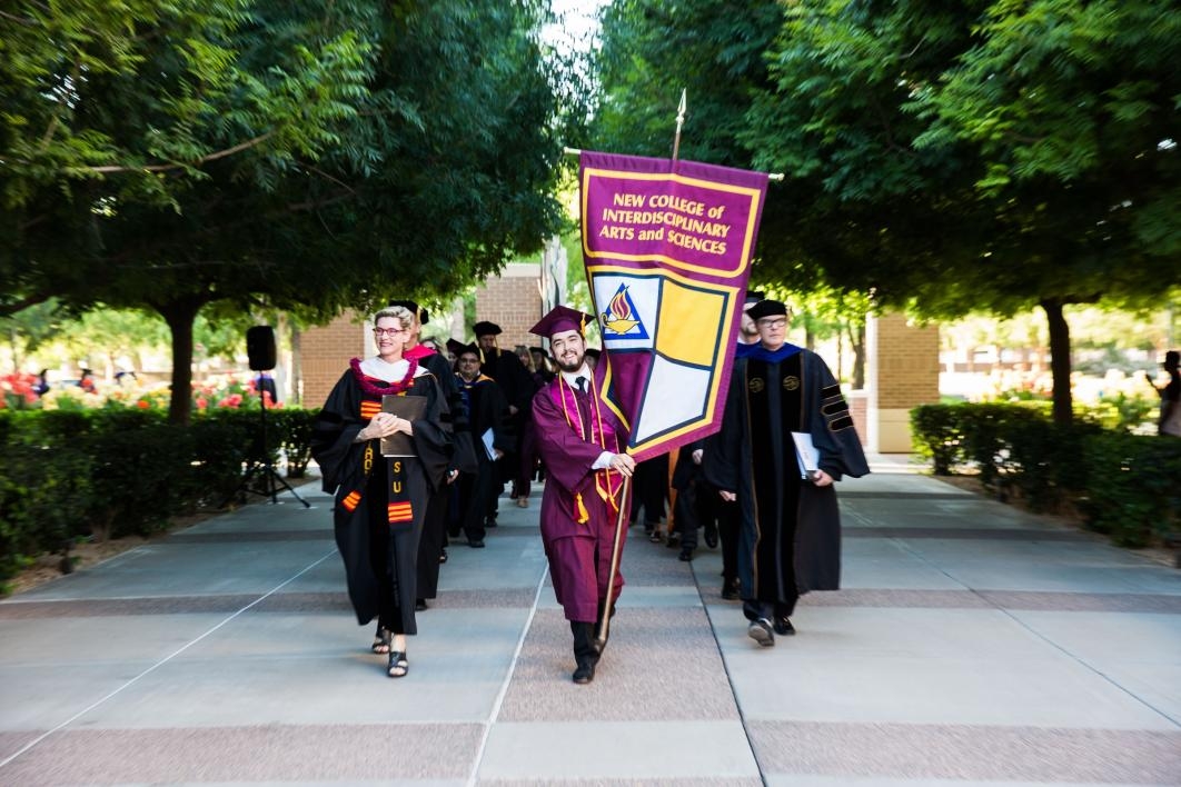 student holding flag walking to convocation