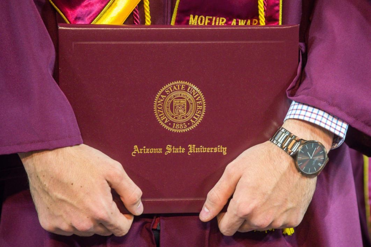 student holding diploma case