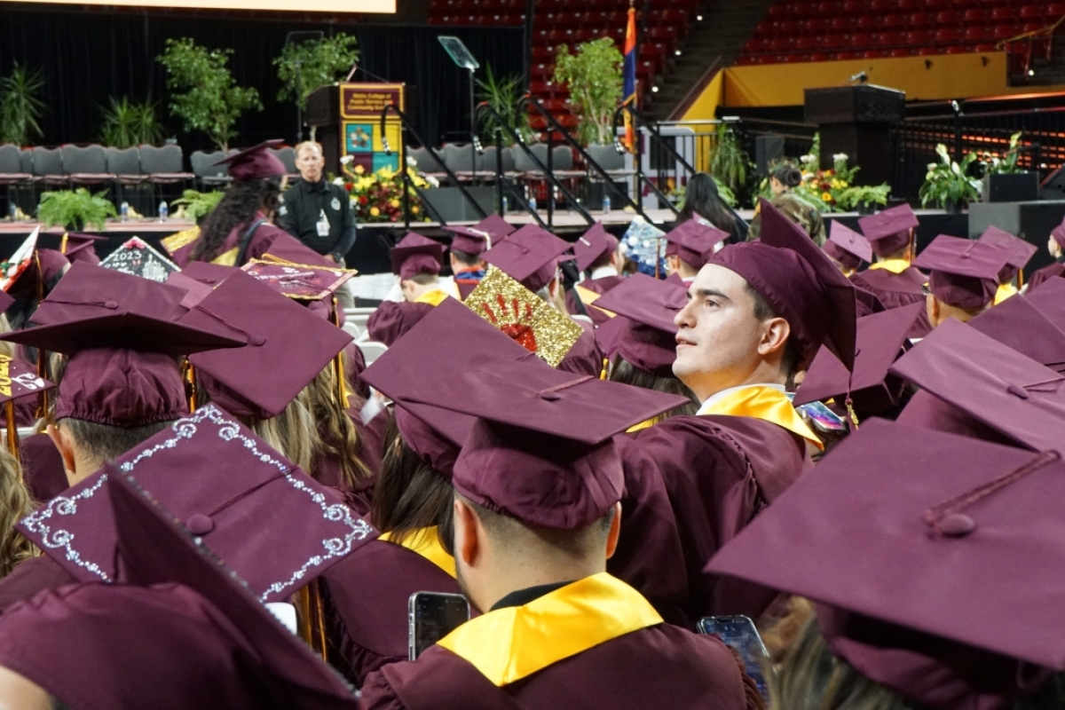 A graduate looks up from a sea of mortarboards.