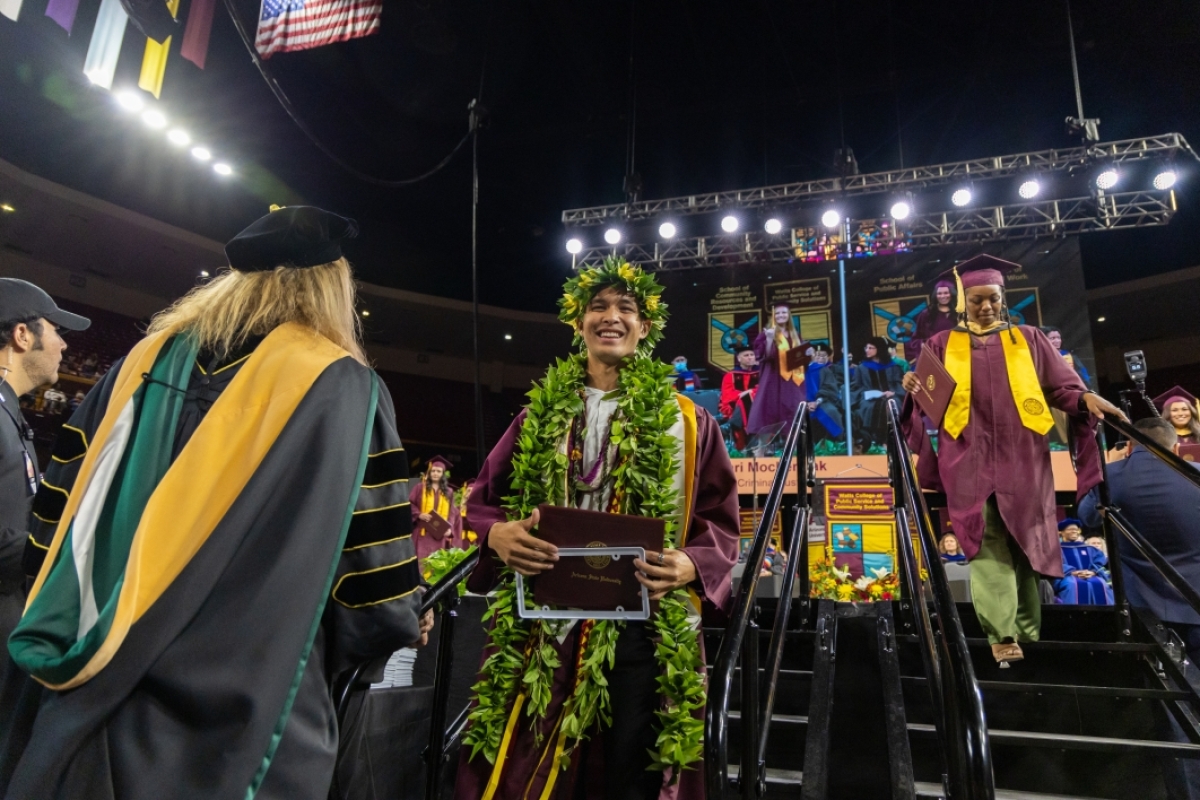 A graduate wears a lei at the Watts College of Public Service and Community Solutions spring 2023 convocation