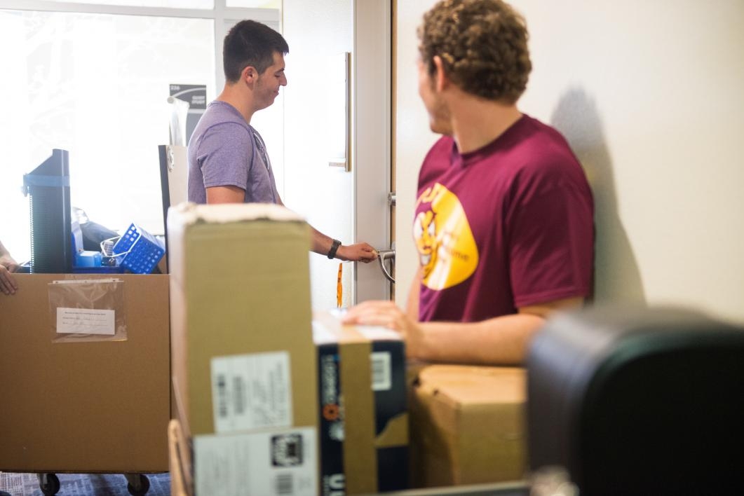 Volunteers help a student move his belongings into the dorm on the Polytechnic campus.