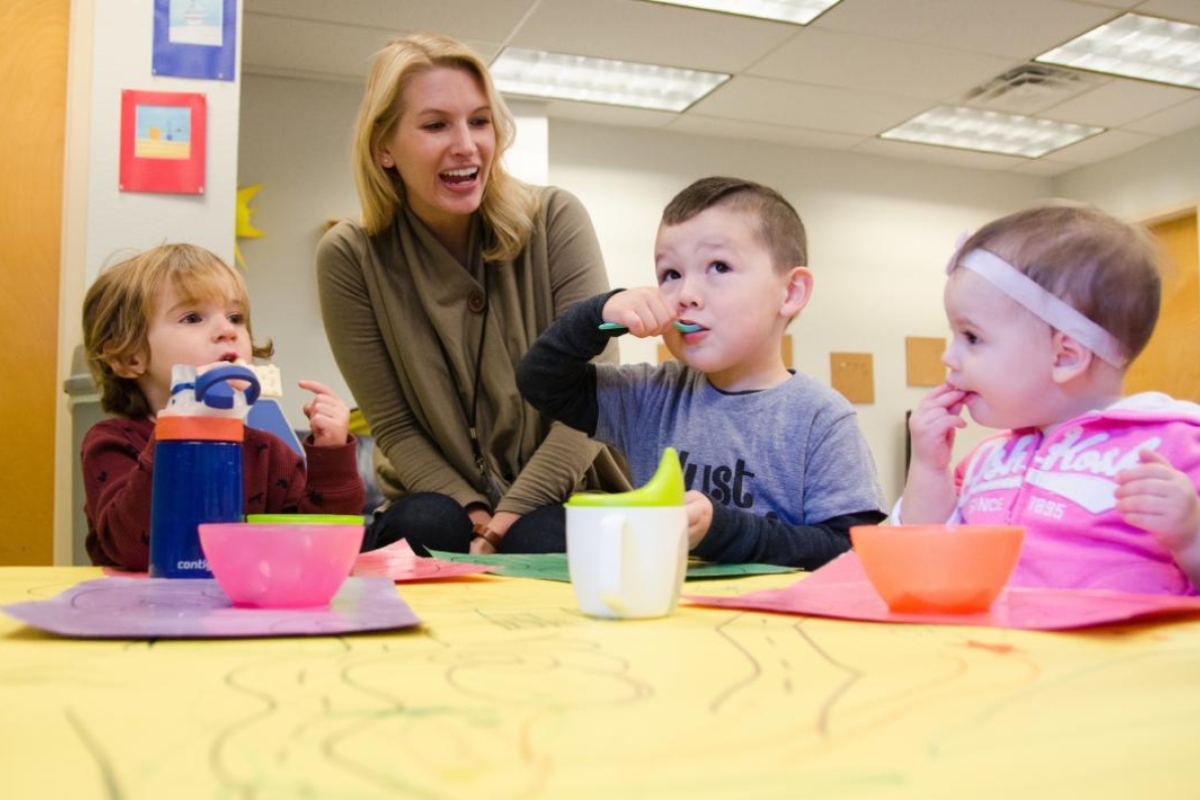 ASU student speaking with toddlers at a table