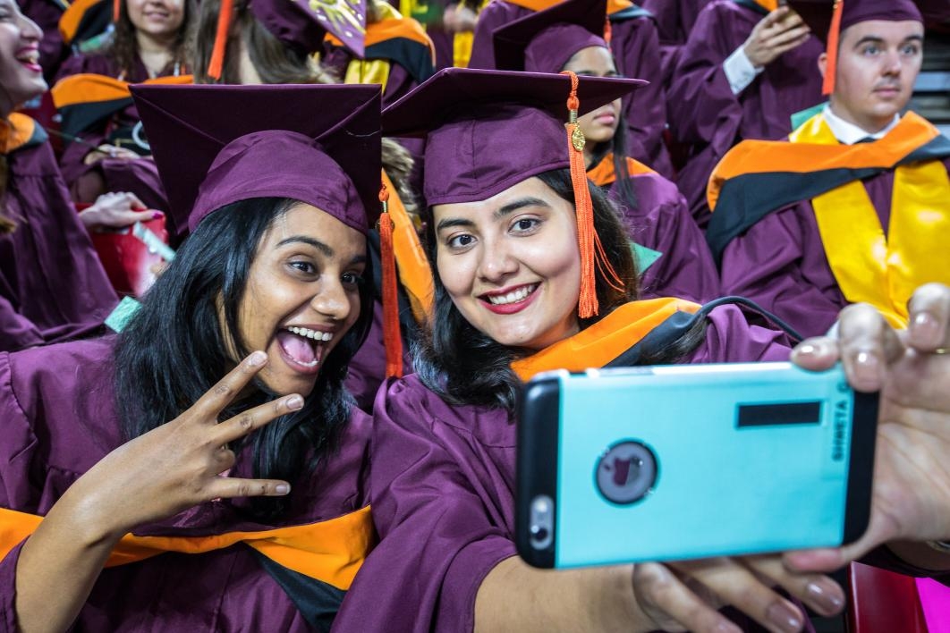 two graduates taking a selfie
