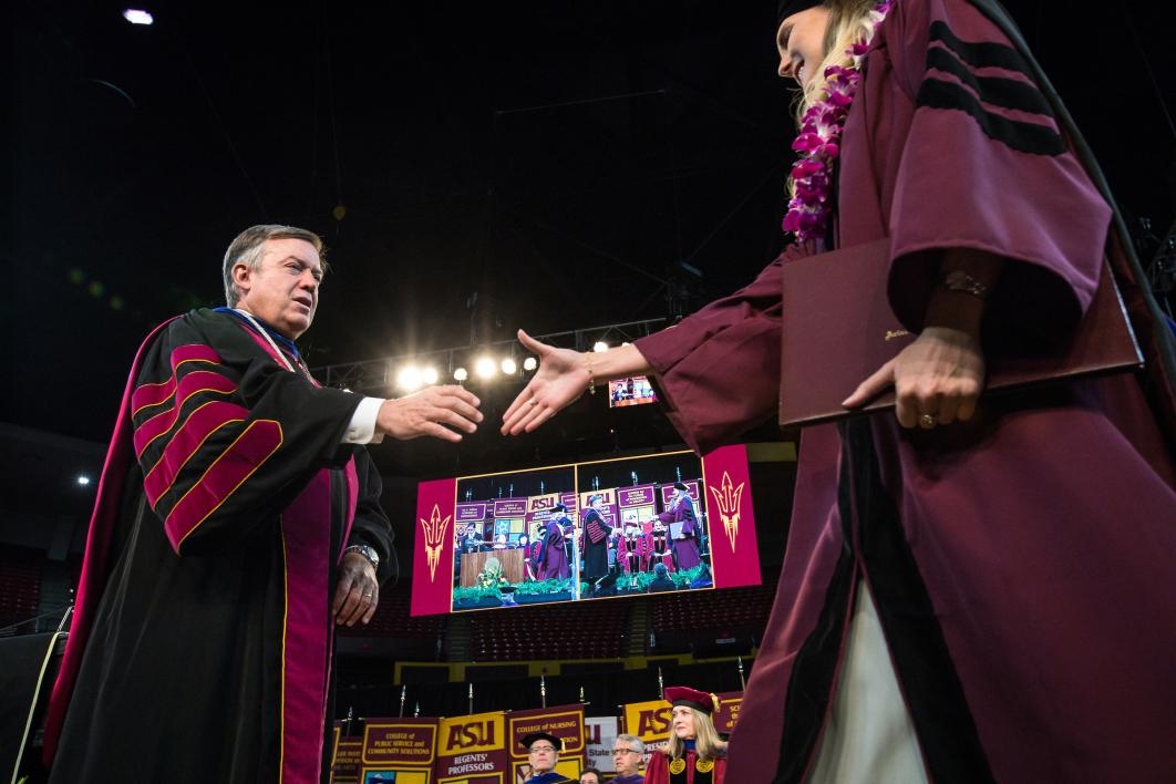 ASU President shaking hands with graduate